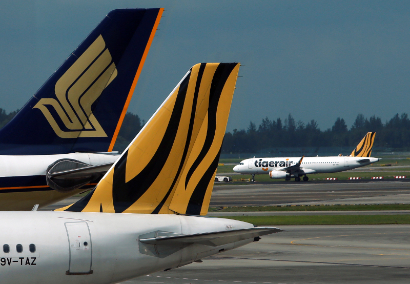 A Tiger Airways plane is towed on the runway past Singapore Airlines and Tiger Airways planes sitting on the tarmac at Changi Airport in Singapore July 21, 2014. u00e2u20acu201d Reuters pic