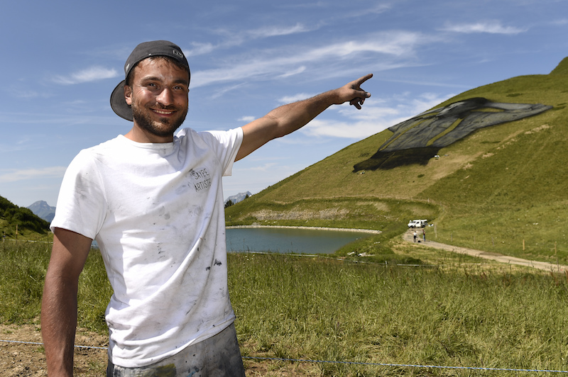 French artist Saype poses in front of his painting. u00e2u20acu201d AFP pic