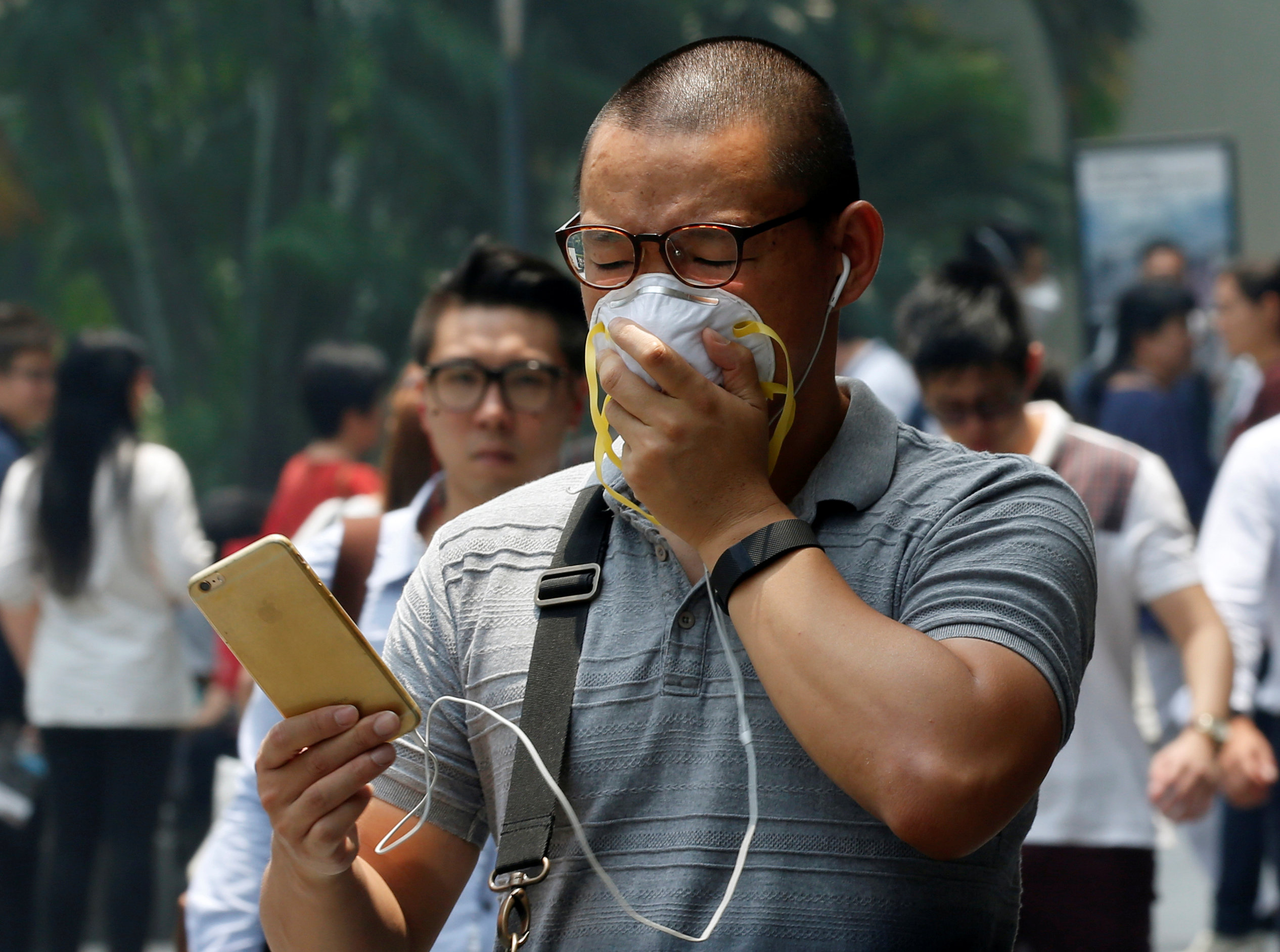 A man covers his face with a mask as haze shrouds Singapore's central business district August 26, 2016. u00e2u20acu201d Reuters pic