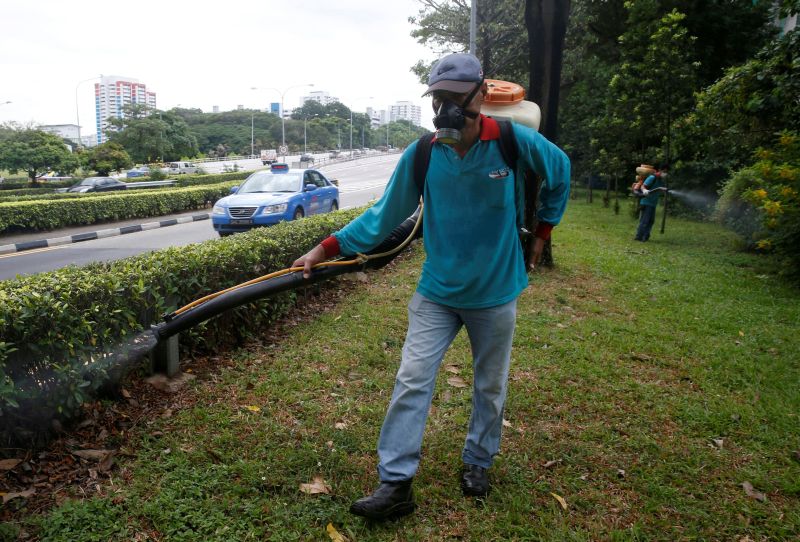 A worker sprays insecticide along the perimeter of a construction site, at an area where locally transmitted Zika cases were discovered in Singapore August 30, 2016. REUTERS/Edgar Su