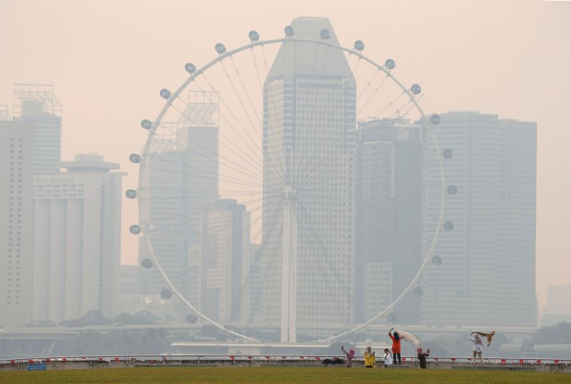 People take photos near the Singapore Flyer observatory wheel shrouded by haze August 26, 2016. u00e2u20acu2022 Reuters pic