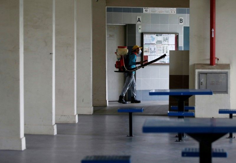 A worker sprays insecticide along the common areas of a public housing estate in Singapore August 30, 2016, at an area where locally transmitted Zika cases were discovered. REUTERS/Edgar Su