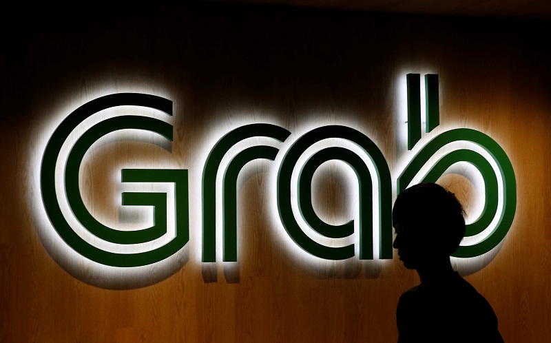 A man passes a Grab signage in their office in Singapore September 23, 2016. u00e2u20acu201d Reuters [oc