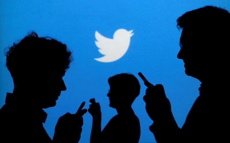 People holding mobile phones are silhouetted against a backdrop projected with the Twitter logo in this illustration picture taken in Warsaw September 27, 2013. u00e2u20acu201d Reuters pic