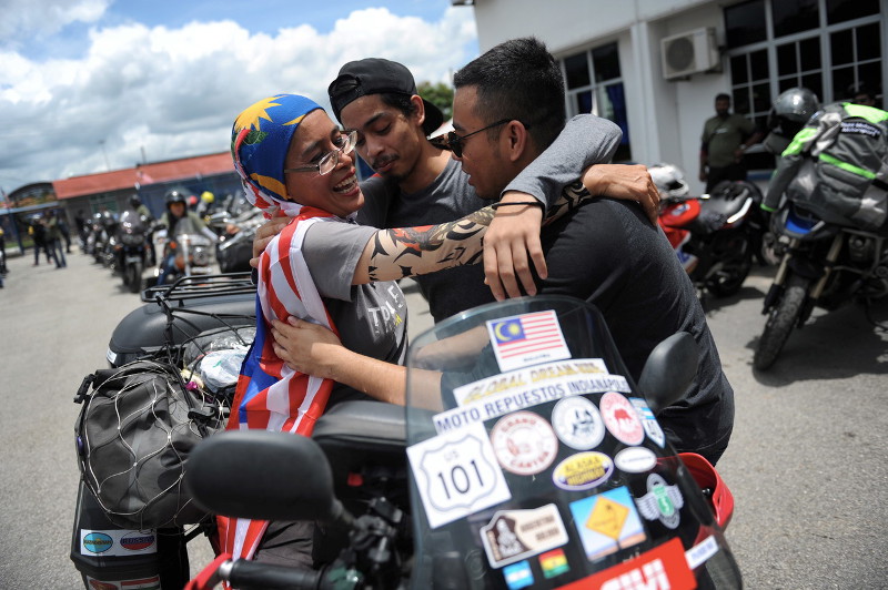 Sports science lecturer Anita Yusof (left) embracing her children after arriving at Bukit Kayu Hitam on September 16, 2016, after successfully riding a motorcycle more than 65,000km across four continents and 40 countries. u00e2u20acu201d Bernama pic