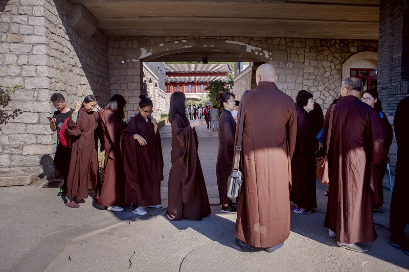Visitors in tunics provided by Longquan Monastery wait to enter the monasteryu00e2u20acu2122s meditation area in northwest Beijing, August 28, 2016. u00e2u20acu201d Picture by Giulia Marchi/The New York Times