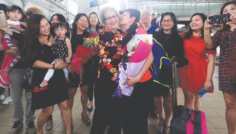Cheong Jun Hoong kisses her grandmother Cheou Tin Goh at the Ipoh KTM train station. u00e2u20acu201d Picture by Farhan Najib Yusoff