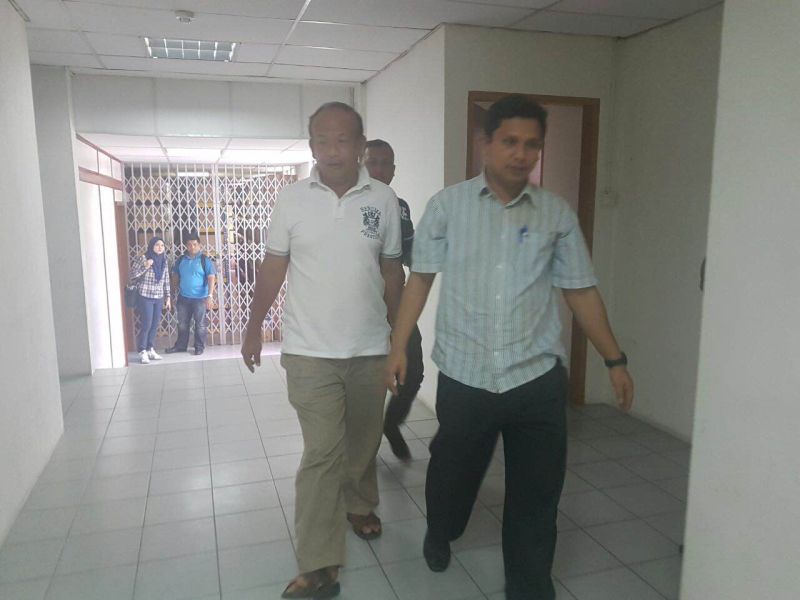 Plantation owner How Kim San is accompanied to the Sessions Court in Kota Kinabalu on September 21, 2016 where he is charged with receiving RM9 million for the illegal sale of state land. u00e2u20acu2022 Picture courtesy of Malaysian Anti Corruption Commission