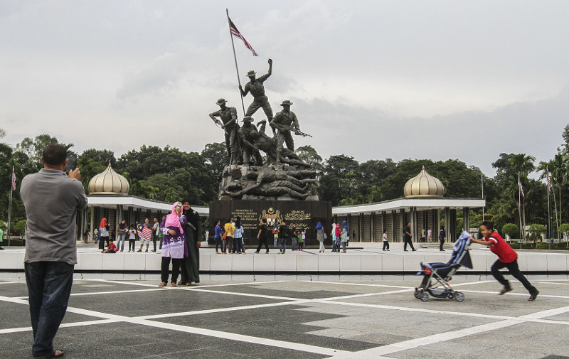 People posing for pictures in front of the National Monument in Kuala Lumpur during the Malaysia Day public holiday, September 16, 2016. u00e2u20acu201d Picture by Yusof Mat Isa