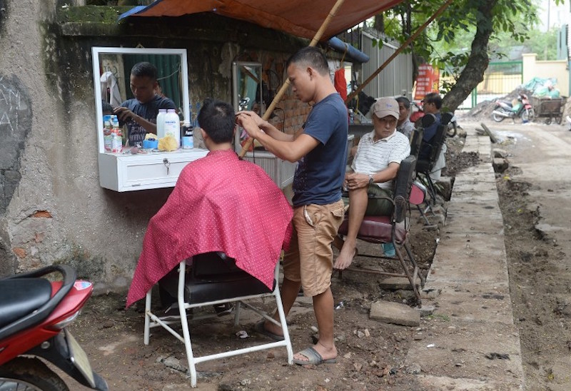 A barber serving a customer at a streetside shop in downtown Hanoi September 12, 2016. u00e2u20acu201d AFP pic