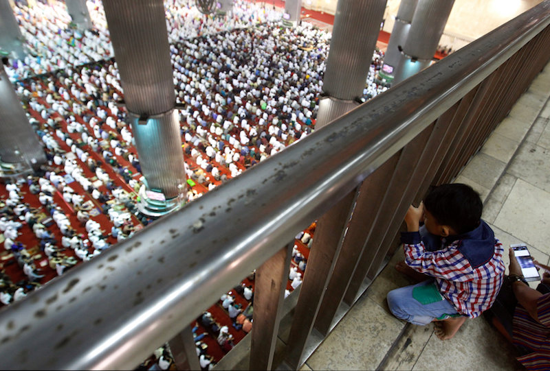 A boy watches people attending prayers for the Muslim holiday of AidilAdha at Istiqlal Mosque in Jakarta, Indonesia September 12, 2016.u00c2u00a0u00e2u20acu201d Reuters pic