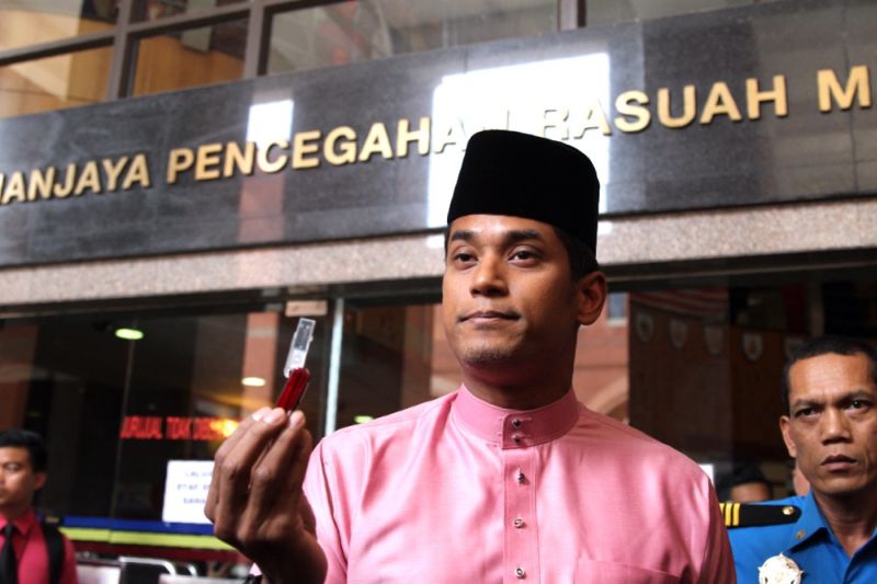 Khairy Jamaluddin is seen holding the pendrive containing information on FAM malpractice outside the MACC headquarters earlier today. u00e2u20acu201d Picture by Choo Choy May