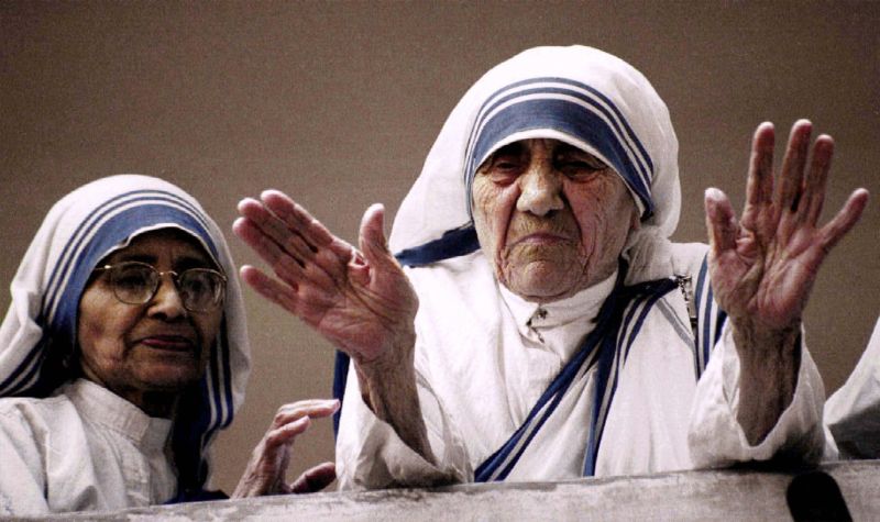 Mother Teresa blesses reporters and photographers gathered in the courtyard of the headquarters of her Missionaries of Charity in the eastern Indian city of Calcutta March 14, 1997. At left is Sister Nirmala. REUTERS