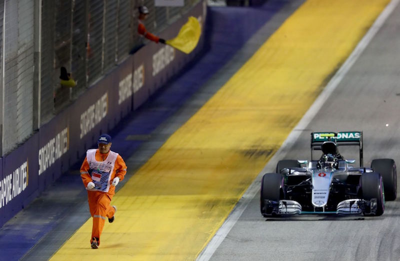 Nico Rosberg turbo past a marshal on track during the Formula One Grand Prix of Singapore at Marina Bay Street Circuit on Sept 18, 2016. u00e2u20acu201d Picture courtesy of Getty Imagesn