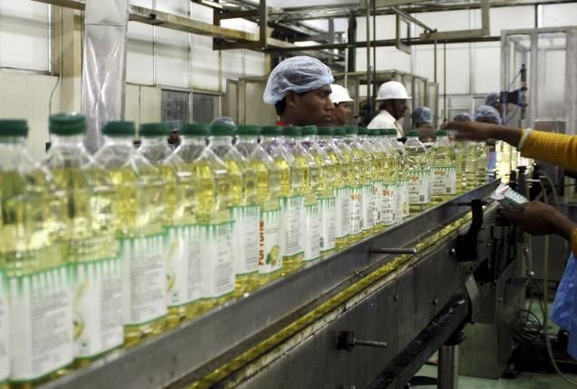 Employees fill plastic bottles with edible oil at an oil refinery plant of Adani Wilmar Ltd, a leading edible oil maker, in Mundra, in this June 10, 2009, file photo. REUTERS/Amit Dave/Files