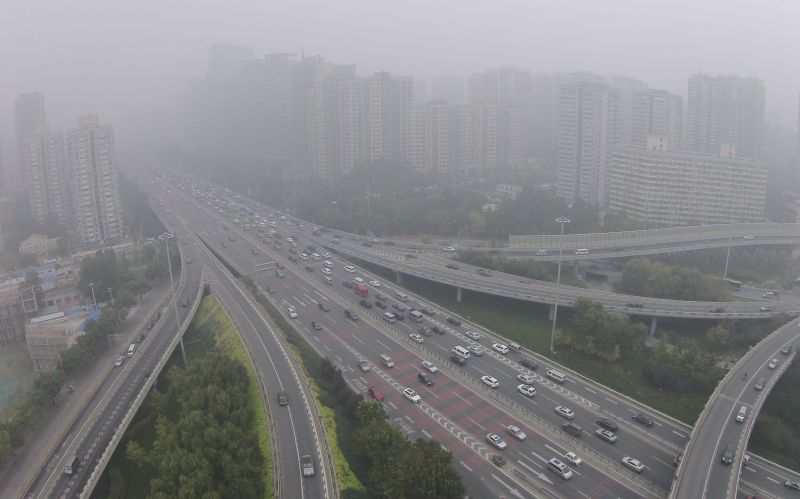 Vehicles drive along the residential buildings on Beijingu00e2u20acu2122s Fourth Ring Road on Oct. 11, 2014. Photo: Reuters/Jason Lee