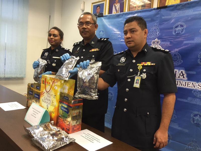 Sabah narcotics department chief Superintendent Mohamed Fadzil A. Rahman (middle) showing the confiscated 5kg syabu in silver packaging. It is Sabahu00e2u20acu2122s second biggest bust this year, after a 6.6kg bust last month. u00e2u20acu2022 Picture by Julia Chan