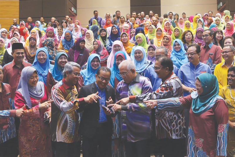 Mahdzir (centre) takes a closer look at the tablet with (from left) Education Ministry director-general Tan Sri Khair Mohamad Yusof, Mohd Noordin, ministry secretary-general Datuk Seri Alias Ahmad and Foziah. u00e2u20acu201d Picture by Azneal Ishak