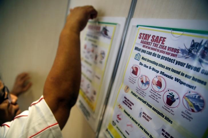 A resident volunteer puts up posters in a lift of a public housing estate in a Zika cluster in Singapore September 2, 2016. u00e2u20acu201d Reuters pic