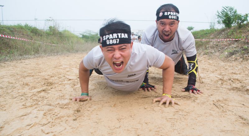  Participants going through the barbed wire obstacle at one of the Spartan Race. ― Picture courtesy of Reebok Spartan Race Malaysia