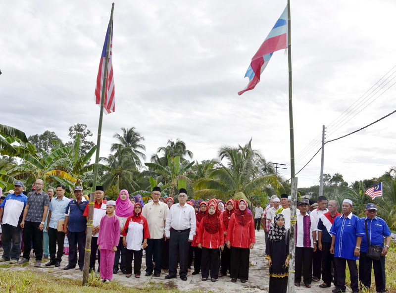 Sabah Youth and Sports Minister Datuk Tawfiq Abu Bakar Titingan singing the national anthem with the community during the Ranggu Zone National Day 2016 level event at Balai Raya Kampung Ranggu in Tawau on September 10, 2016. u00e2u20acu201d Bernama pic