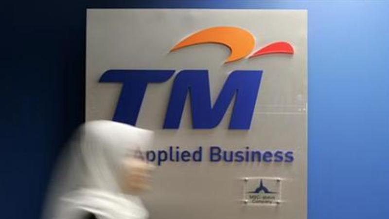 A woman walks past a logo display of Telekom Malaysia at its office in Cyberjaya outside Kuala Lumpur May 16, 2006. u00e2u20acu201d Reuters pic