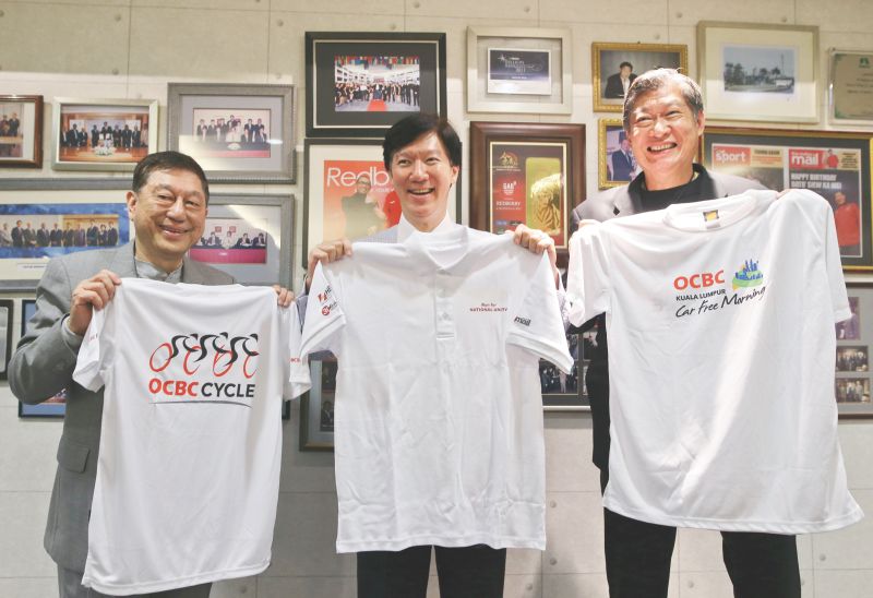(From left) Dr Chan, Ong and Redberry chief executive officer Datuk Siew Ka Wei show T-Shirts they exchanged with each other to mark their collaboration. u00e2u20acu201d Picture by Azneal Ishak 