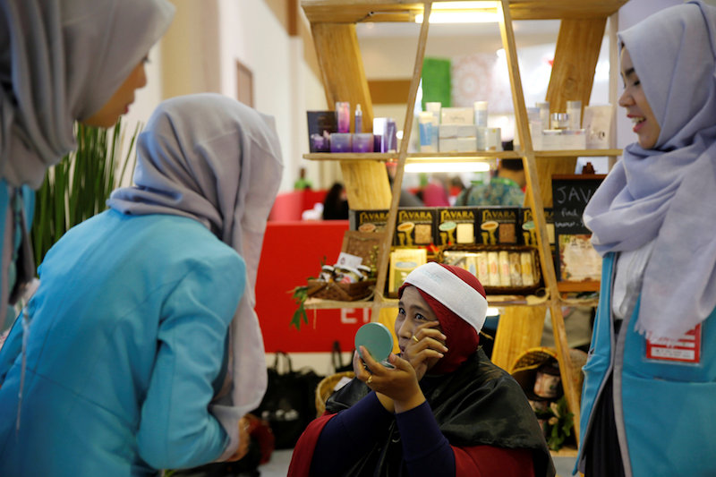 A saleswoman from Wardah cosmetics, an Indonesian brand specialising in products for Muslim women, speaks with a customer at a sales booth in a mall in Jakarta, Indonesia, August 3, 2016. u00e2u20acu201d Reuters pic 