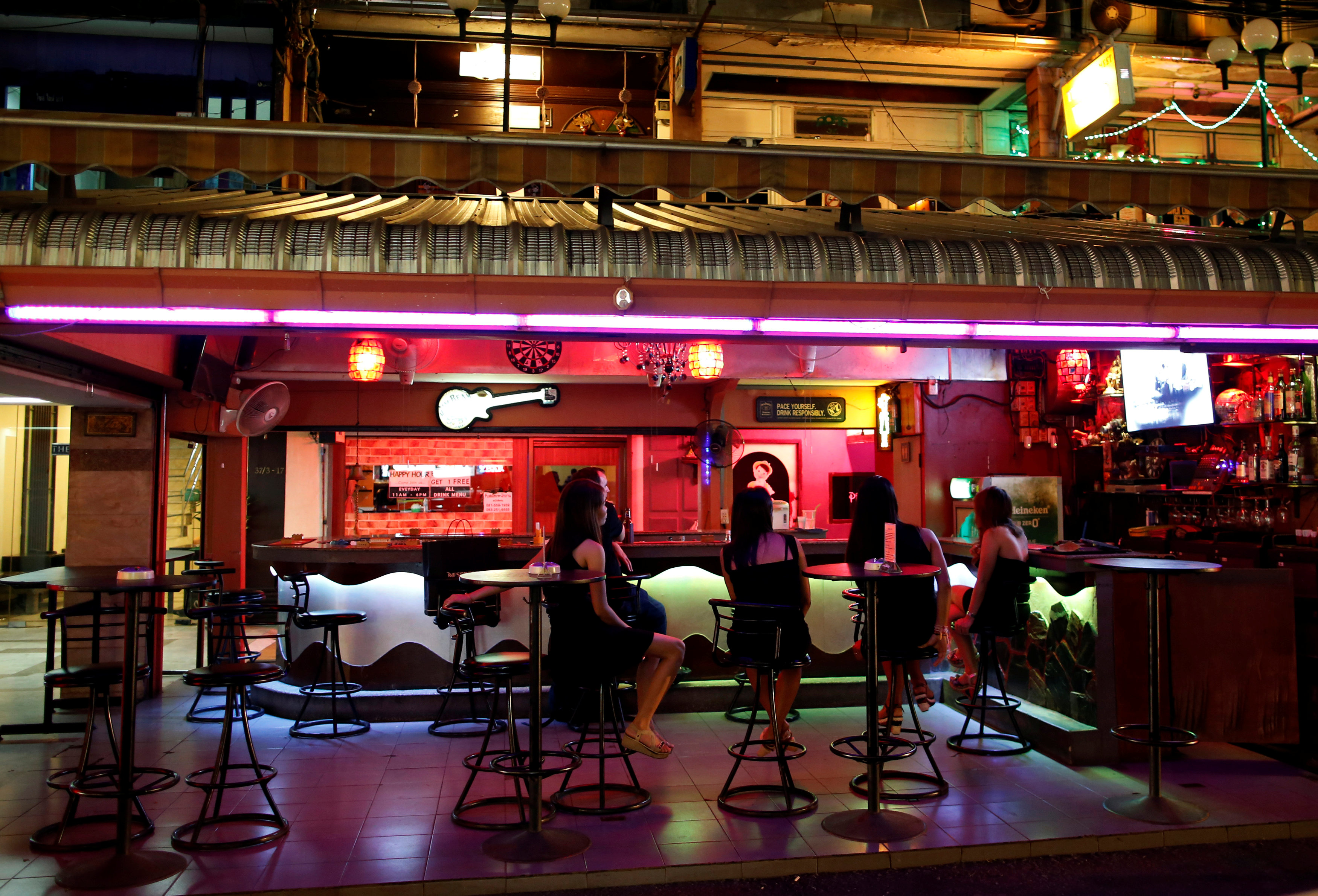 Women sit inside a bar in a red light district in Bangkok, Thailand, October 14, 2016. REUTERS/Issei Katon