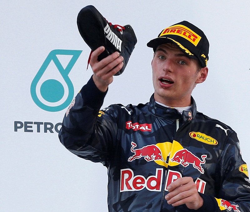 Red Bull’s Max Verstappenof the Netherlands drinks from the shoe of Red Bull’s Daniel Ricciardo of Australia, on the podium in Sepang October 2, 2016. 