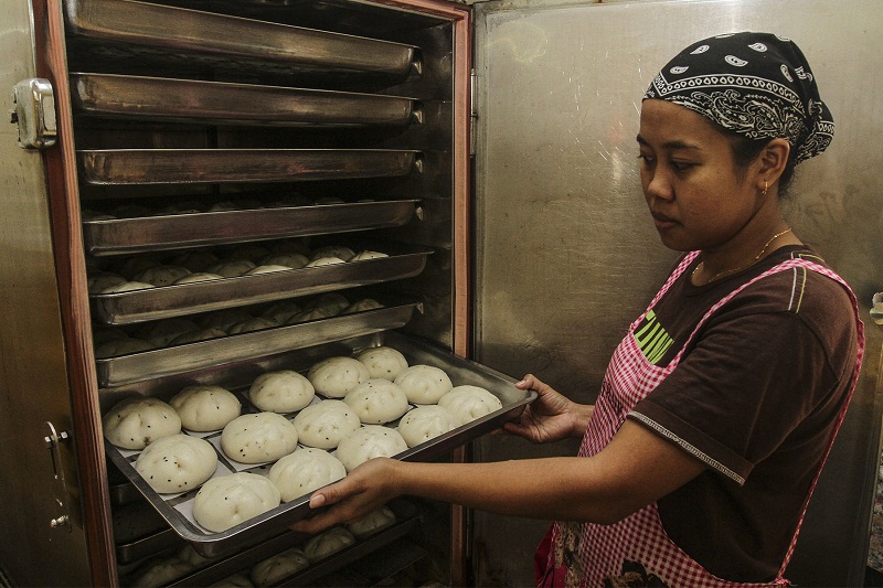 A worker from Lam’s restaurant putting a tray of pau into the steam machine at Restaurant Klang Food Centre in Klang, Selangor October 7, 2016.