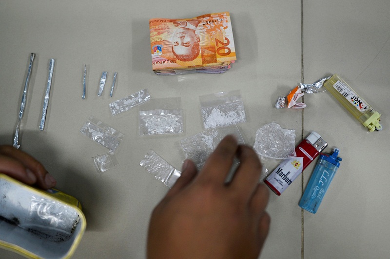 A police officer displays confiscated sachets of crystal meth (locally known as u00e2u20acu02dcshabuu00e2u20acu2122), cash and other drug paraphernalia at a police station, after police conducted a u00e2u20acu02dcOne Time Bigtimeu00e2u20acu2122 operation against illegal drugs in metro Manila, Philippin