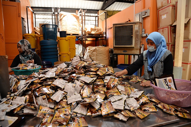 Packing up the coffee...the final process as workers pack up each small packet of coffee. — Picture by K.E.Ooi