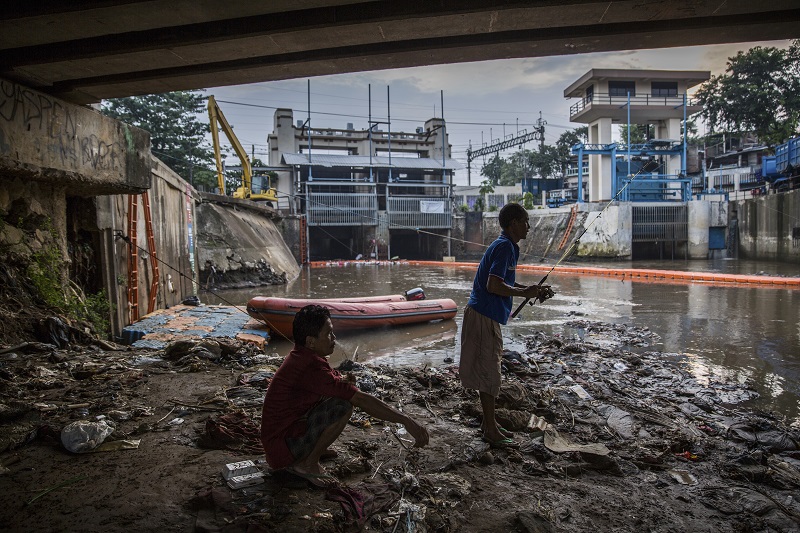 A man fishes in the polluted waters near a floodgate in the Manggarai neighbourhood of Jakarta, Indonesia, August 26, 2016. Jakarta is one of Asia’s largest cities, and the public works department has determined that about 20 per cent of its daily waste ends up in local rivers and canals. — Picture by Kemal Jufri/The New York Times