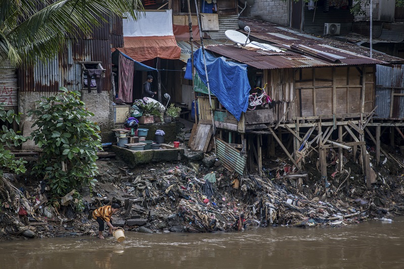 A person dips a bucket into the water in a slum neighbourhood along a riverbank in Jakarta, Indonesia, August 26, 2016. — Picture by Kemal Jufri/The New York Times