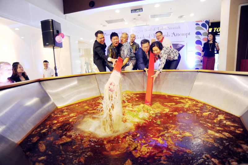 Datuk Prof Dr Sim Kui Hian (second right) stirs the huge bowl of Sarawak laksa with Chef Wan (third left) in a bid to set a record for the Malaysia Book of Records. u00e2u20acu2022 Bernama pic