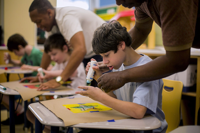 Nicholas Mir, who was born with microcephaly, gets help with a project in his art class at Manhattan Star Academy in New York August 4, 2016. — Picture by Sam Hodgson/The New York Times