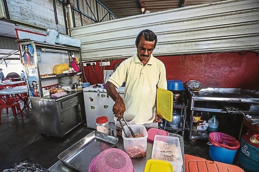 Subra prepares a meal at his stall in Taman Mewah, Ampang. ― Picture by Firdaus Latif