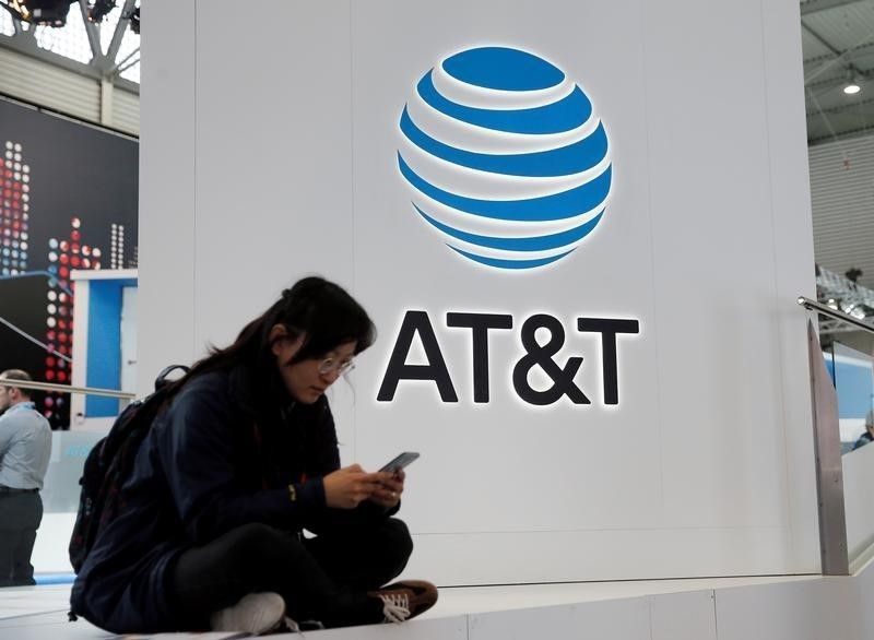 A woman looks at her mobile next to AT&T logo during the Mobile World Congress in Barcelona February 25, 2016. u00e2u20acu201d Reuters pic
