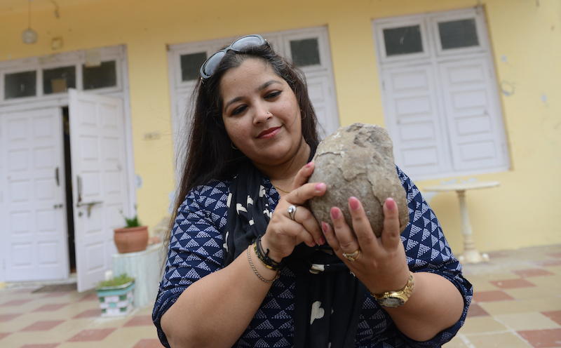 This picture taken on September 1, 2016 shows 'Dinosaur Princess' Aaliya Sultana Babi holding a fossilised dinosaur egg at her palace in Balasinor, some 100 kms from Ahmedabad. u00e2u20acu201d AFP pic