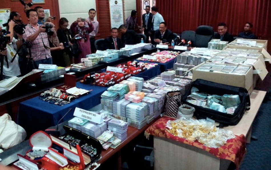 MACC held a news conference in KK where they announced and displayed a whopping haul of RM114 million worth in cash, jewellery, land grants and branded goods. u00e2u20acu201d Bernama pic