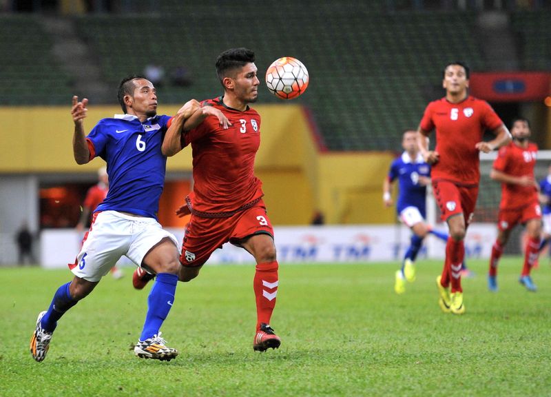 Malaysia's Mohd Fazrul Hazli Mohd Kadri (left) tussling with Afghanistan's Hassan Amin in a friendly match at the Shah Alam Stadium October 11, 2016  u00e2u20acu201d Bernama pic