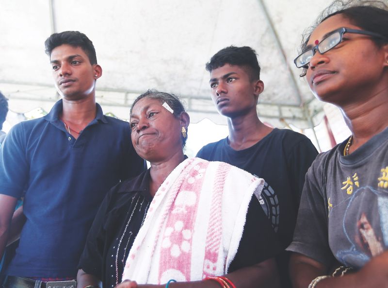  (From left) Logeswaranu00e2u20acu2122s siblings Sethupathy, 16-year-old Hehram (second right) and Vikneswary (right) stand by Nageswary during Logeswaranu00e2u20acu2122s funeral at their home in Ladang Rubana yesterday. u00e2u20acu201d Picture by Farhan Najib