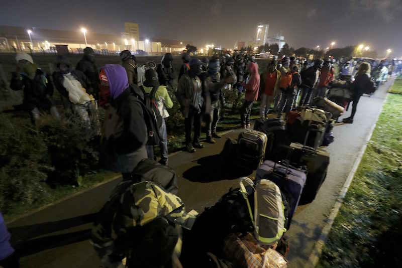 Migrants with their belongings queue as their evacuation and transfer to reception centres in France, and the dismantlement of the camp called the 'Jungle' in Calais, France, starts October 24, 2016. — Reuters pic