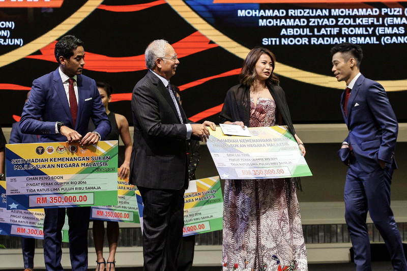 Datuk Seri Najib Razak presenting prize Incentive scheme awards to badminton mixed doubles pair Chan Peng Soon (right) and Goh Liu Ying (second right) who won the silver medal at the Rio Olympic, in Kuala Lumpur, October 8, 2016. u00e2u20acu201d Bernama pic
