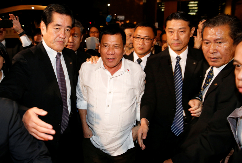 Philippine President Rodrigo Duterte is escorted by bodyguards after he met his supporters outside a hotel in Tokyo, Japan October 25, 2016. u00e2u20acu201d Reuters pic
