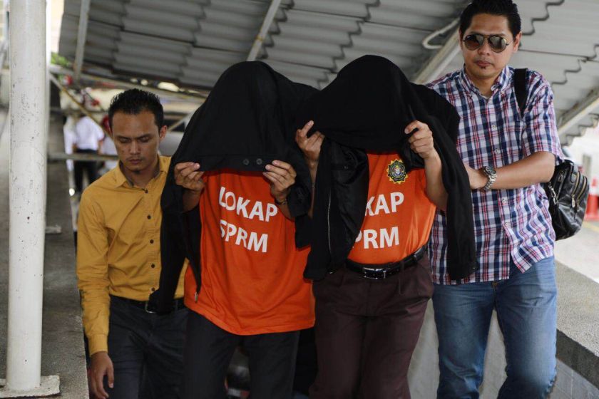 Some of the 14 suspects who were remanded are pictured at the Kota Kinabalu magistrate court building. u00e2u20acu201d Picture courtesy of the Malaysian Anti-Corruption Commission