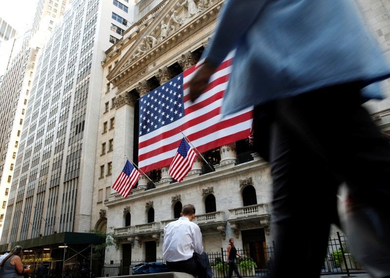 People sit outside the New York Stock Exchange (NYSE) during the morning commute in New York City September 15, 2016. REUTERS/Brendan McDermid