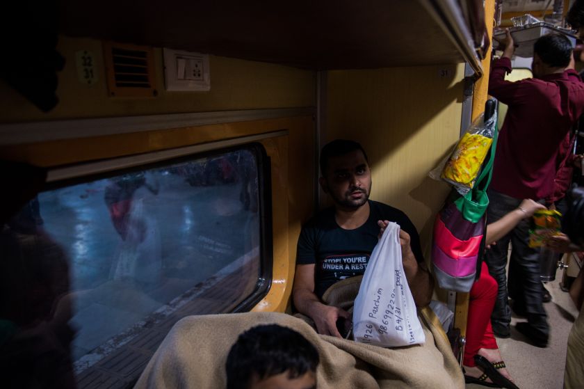 A passenger holds a food delivery from TravelKhana inside the train at the Mathura Junction in Mathura. u00e2u20acu2022 AFP pic