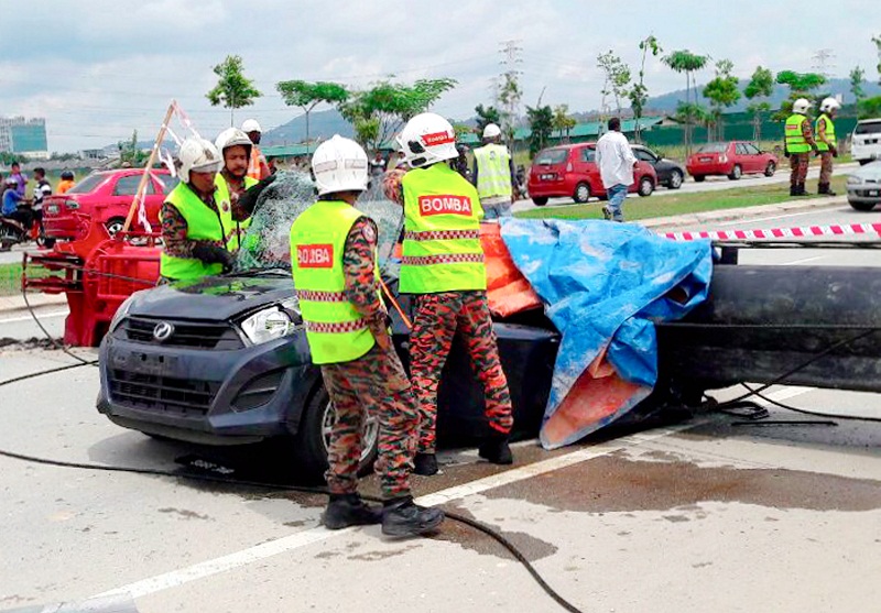 Firemen try to remove the bodies of the two victims who were crushed to death after a piledriver fell on their car in Meru, Klang November 4, 2016.u00e2u20acu201dBernama pic